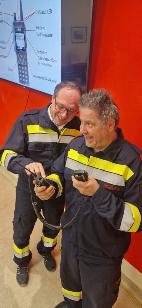 Zwei stehende Personen bedienen ein Funkgerät