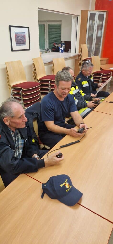 Bild zeigt Feuerwehrleute bei der Bedienung von Funkgeräten